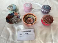 Six small hand-painted ceramic bowls on fabric