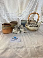 Group shot showing teapot, four cups, three planters/jars