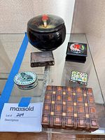 Six of the seven boxes grouped on glass shelf