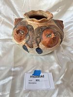 Front view showing painted faces and scalloped rim