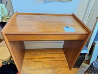Front view of wooden vanity table, lid closed