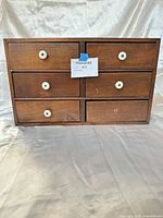 Front view of cabinet showing six drawers with knobs