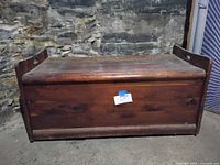 Closed wood chest front view against stone wall