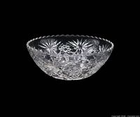 Side view of clear pressed glass bowl showing scalloped rim and starburst pattern