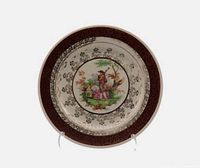 Front view of plate showing pastoral scene and gold border