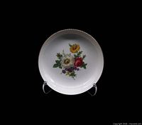 Front view of porcelain coupe soup bowl displaying floral bouquet and gold rim