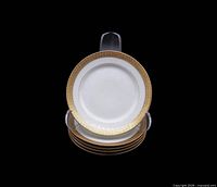 Stack of five porcelain plates with gold rim