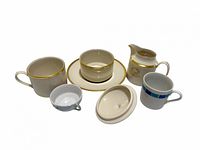 Front angled view of all seven porcelain pieces laid out