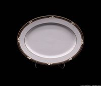 Front view of 13-inch oval platter showing brown rim with ivory bow motif