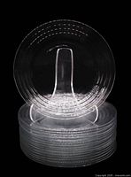 Stack of seventeen clear Libbey Hoops plates with one plate displayed upright on stand