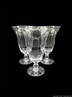Three clear pedestal water goblets grouped together