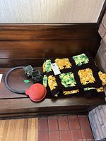 Blanket folded next to two metal candle holders on bench