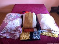Stack of pillows, knit throws, blankets on bed