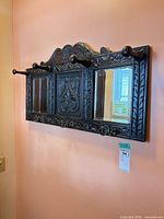 Front view showing entire carved coat rack with mirrors and hooks