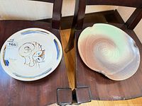 Two bowls side by side on chairs showing size difference and glazing