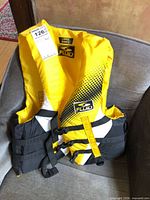 Front view of Fluid life jacket showing color, branding, size tag, and buckle system