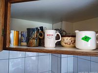Shelf view showing multiple mugs, bowl and creamer