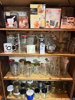 Shelved boxed kitchen gadgets, beer glasses, assorted drinkware and glass bowls