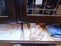 Drawer with embroidered cloth, crochet lace pieces and folded printed blue napkins