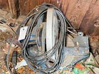 Top view of dusty Ryobi miter saw with wrapped power cord