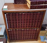 Front view of wooden bookcase holding red bound books