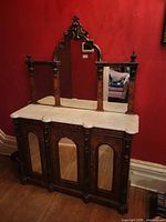 Full view of credenza showing marble top, mirrored back, carved crest, doors and columns