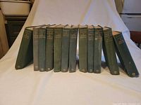 Front view of 12 Arthur Ransome green cloth hardcovers lined up