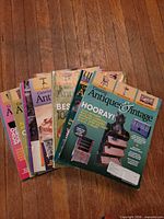 Stack of approximately 10 Canadian Antiques & Vintage magazines on wooden floor