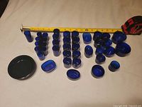 Full group of cobalt blue glass liners displayed with tape for scale