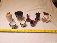 Full group of eight earthenware items with measuring tape for scale