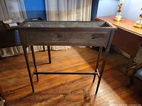 Full front and side view of plant stand showing cane panel and overall form