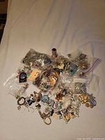 Overall view of lot showing multiple bags of mixed costume jewelry parts