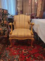 Front view of giltwood armchair showing full frame and upholstery