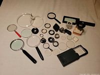 Full view of all magnifiers, loupes, lenses and accessories laid out on surface