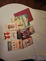 All eight books laid out on bed showing covers