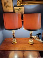 pair of lamps with peach drum shades on wooden surface