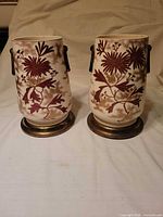 Front view of both ceramic vases showing floral pattern and brass bases
