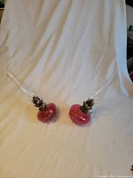 Pair of cranberry glass kerosene lamps shown on white backdrop