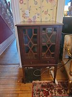 Front view showing glazed doors, drawer, legs