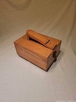 Closed wooden shoeshine box, angled footrest visible