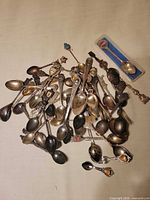 Overhead view showing full assortment of souvenir spoons piled together