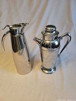 Overview of both stainless steel pitchers standing side by side