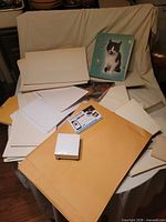 Overview of lot showing envelopes, paper stacks, binder, notebook, sticky note cube