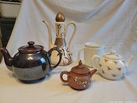 Group shot of all five ceramic tea and coffee pots