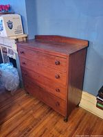 Front view of 4-drawer chest showing overall design, knobs, feet