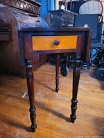 Front view showing drawer, one leaf down, turned legs