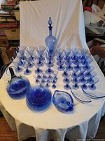 Full set of blue glassware, stemware plates bowls decanter on table
