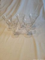 Group view of five clear glass stemmed water goblets