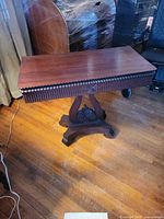 Full view of mahogany veneer tea table on pedestal base