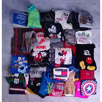 Top view of 30 tops and 5 pants laid flat showing brand logos and graphics